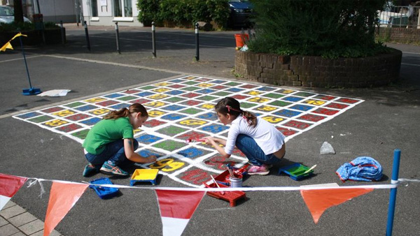 Spielende Kinder malen mit Kreide